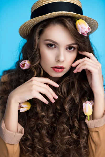 Sensual mujer joven en sombrero canotier con flores en su largo pelo rizado - foto de stock