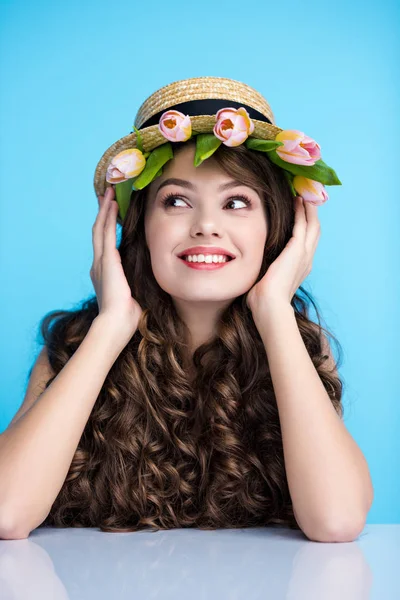 Glückliche junge Frau mit Bootsmütze und schönen Tulpen darunter — Stockfoto