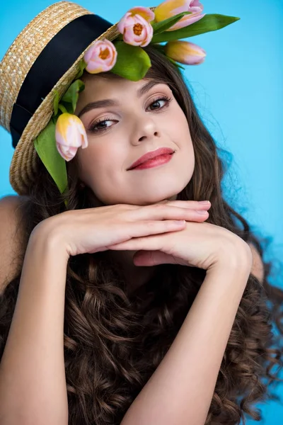 Heureuse jeune femme en chapeau canotier avec des fleurs de tulipe sous elle — Photo de stock