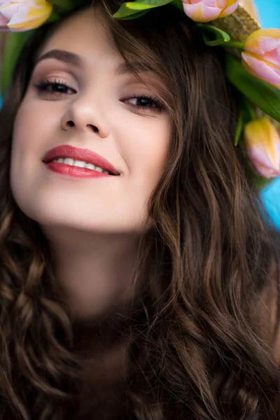 Retrato de cerca de mujer joven atractiva con corona hecha de flores de tulipán - foto de stock