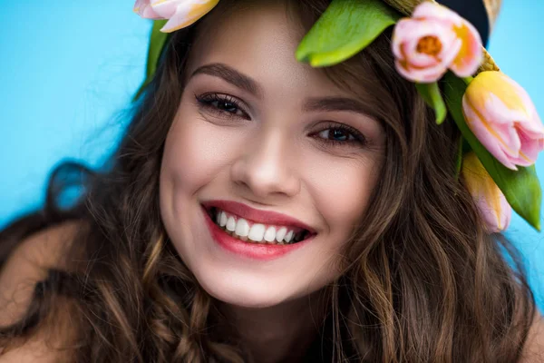 Nahaufnahme Porträt einer glücklichen jungen Frau mit Kranz aus Tulpenblumen — Stockfoto