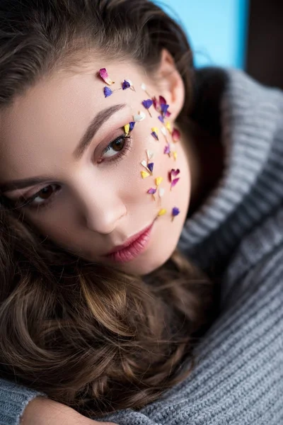 Portrait en gros plan de la femme avec des fleurs sur le visage en pull chaud — Photo de stock