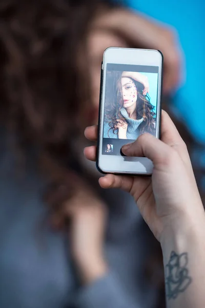 Tiro cortado de pessoa usando smartphone e fotografar sensual jovem — Fotografia de Stock