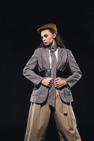 Vista de ángulo bajo de la mujer joven elegante de moda posando aislado en negro - foto de stock