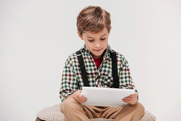 Cute smiling little boy using digital tablet isolated on grey — Stock Photo