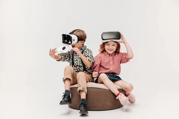 Adorables niños felices usando auriculares de realidad virtual aislados en gris - foto de stock