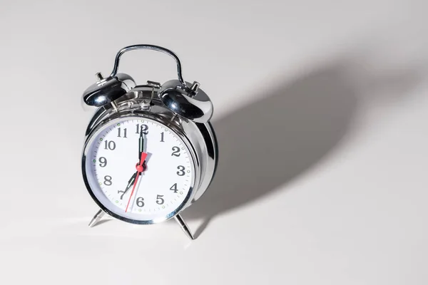 Close-up view of shiny alarm clock with shadow on grey — Stock Photo