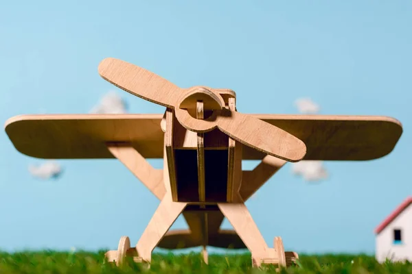 Vista de cerca del avión de juguete de madera sobre hierba verde - foto de stock
