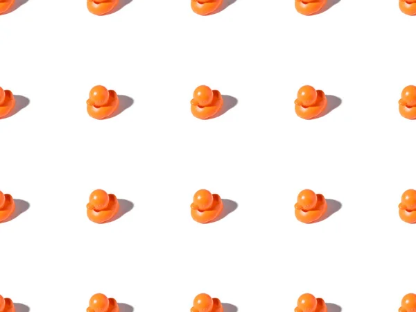 Motif sans couture de petits canards en caoutchouc orange jouets sur blanc — Photo de stock