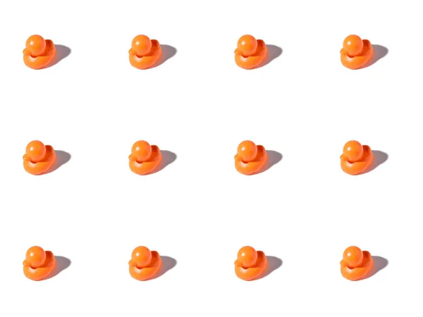 Fundo com pequenos patos de borracha laranja no branco — Fotografia de Stock