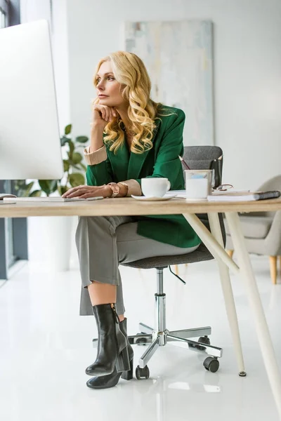 Atractiva mujer de negocios de mediana edad utilizando la computadora de escritorio en el lugar de trabajo — Stock Photo