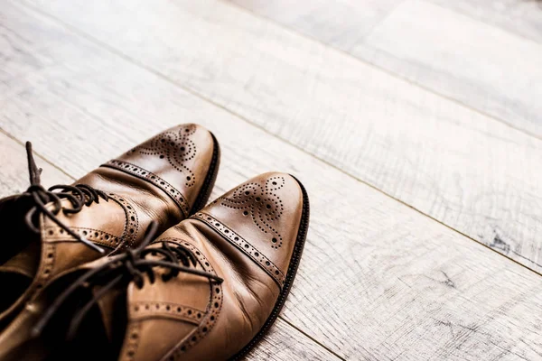 Pair of leather brown shoes on wooden floor — Stock Photo