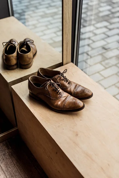 Високий кут зору сучасного коричневого чоловічого взуття на вітрині в магазині — стокове фото