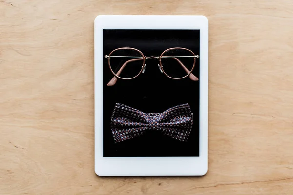 Top view of glasses and tie bow on tablet — Stock Photo