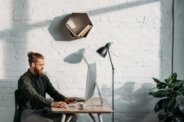 Seitenansicht eines gutaussehenden Geschäftsmannes, der mit dem Computer im Büro arbeitet — Stockfoto