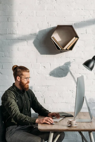 Vista lateral de empresário bonito que trabalha com computador no escritório — Fotografia de Stock