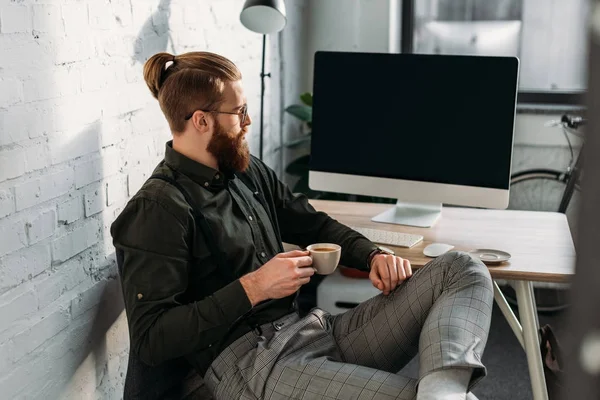 Schöner Geschäftsmann sitzt mit Tasse Kaffee im Büro — Stockfoto