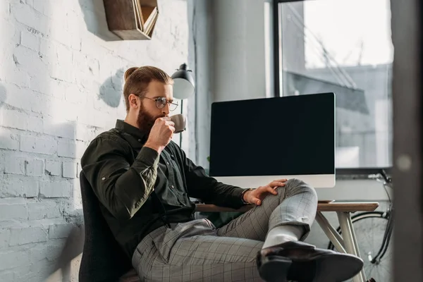 Guapo hombre de negocios beber café en la oficina - foto de stock