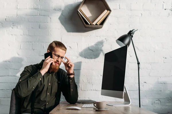 Handsome businessman talking by smartphone in office — Stock Photo