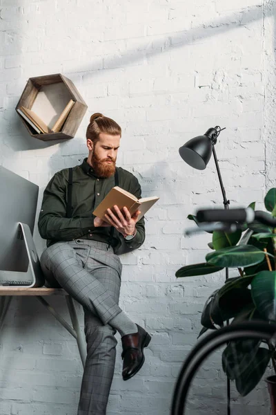 Homem de negócios bonito sentado na mesa e livro de leitura — Fotografia de Stock