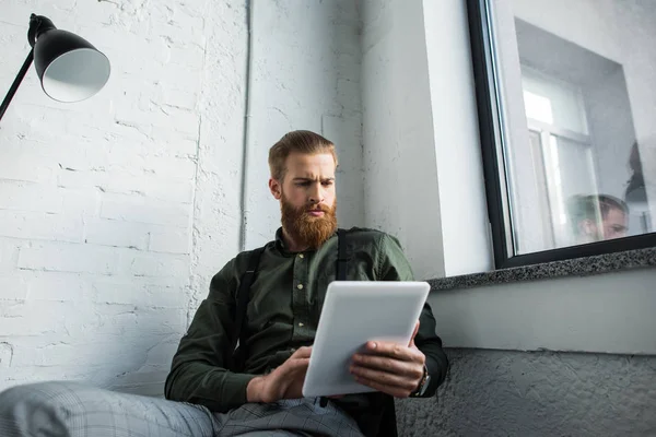 Homme d'affaires barbu utilisant tablette dans le bureau — Photo de stock