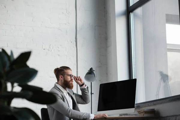 Geschäftsmann berührt Brille und schaut weg — Stockfoto