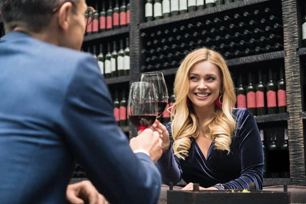 Atractiva pareja de adultos tintineo vasos de vino en el restaurante - foto de stock