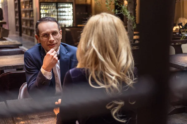 Handsome adult man talking to his girlfriend at restaurant — Stock Photo