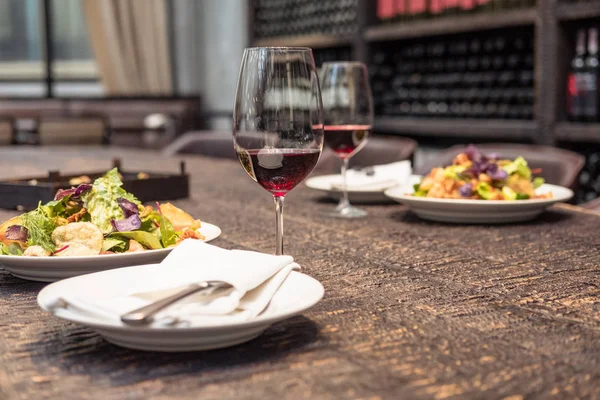 Delicious salad with wine on rustic wooden table for romantic dinner at luxury restaurant — Stock Photo