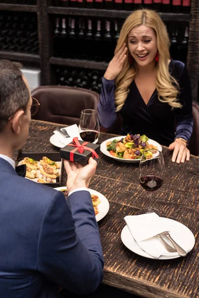 Mann überreicht Freundin Valentinstag-Geschenk im Restaurant — Stockfoto