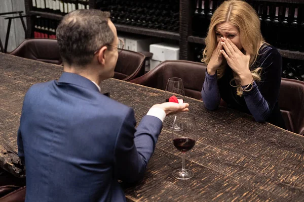 Adult man proposing his shocked girlfriend at restaurant — Stock Photo