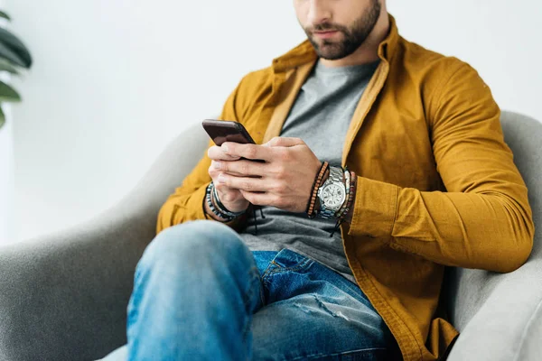 Imagen recortada de hombre guapo usando teléfono inteligente - foto de stock