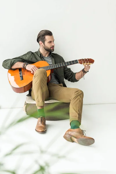 Bel homme accordant guitare acoustique — Photo de stock