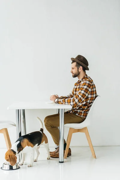 Side view of man and dog at kitchen — Stock Photo