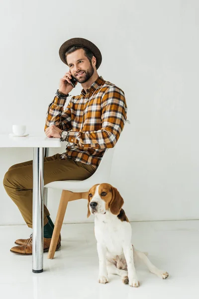 Mann spricht per Smartphone, Hund sitzt auf dem Boden — Stockfoto