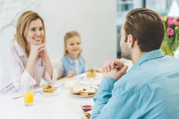 Foco seletivo do homem tomando café da manhã junto com a família em casa — Fotografia de Stock