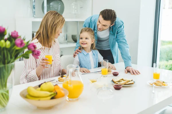 Familia feliz desayunando juntos en casa - foto de stock