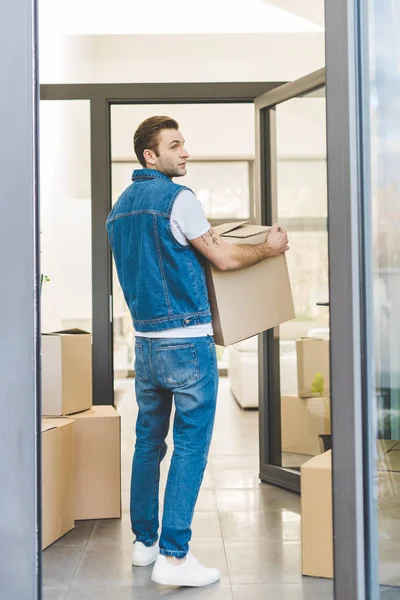 Back view of man with cardboard box moving new house — Stock Photo