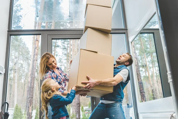 Happy family holding cardboard boxes together at new home, moving home concept — Stock Photo