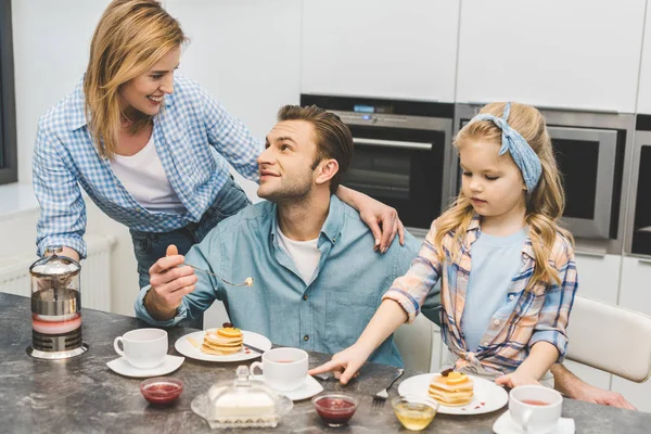 Eltern und kleine Tochter frühstücken gemeinsam zu Hause — Stockfoto