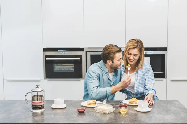 Portrait of couple having breakfast together in kitchen at home — Stock Photo