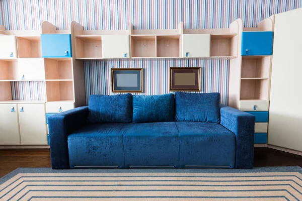 Nahaufnahme von blauem Sofa und Holzschrank im Wohnzimmer — Stockfoto