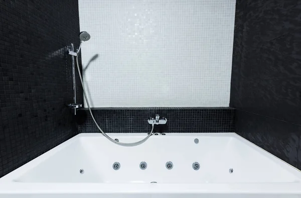 Vista del moderno tubo de baño en baño en colores blanco y negro - foto de stock