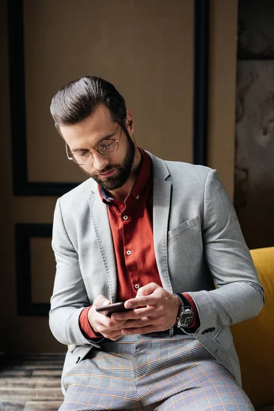 Hombre elegante guapo en gafas usando teléfono inteligente — Stock Photo