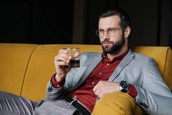 Stylish handsome man holding glass of whiskey — Stock Photo
