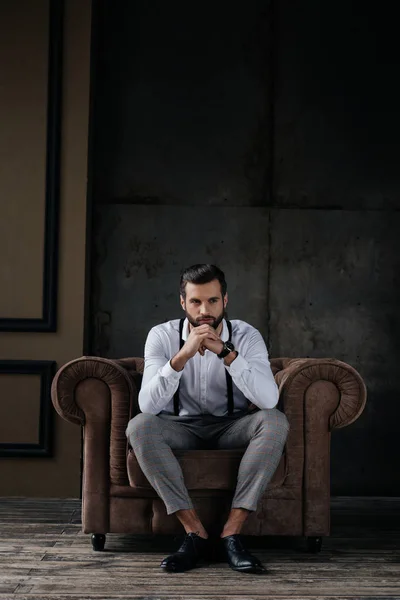 Homem elegante bonito pensando e sentado em poltrona — Fotografia de Stock