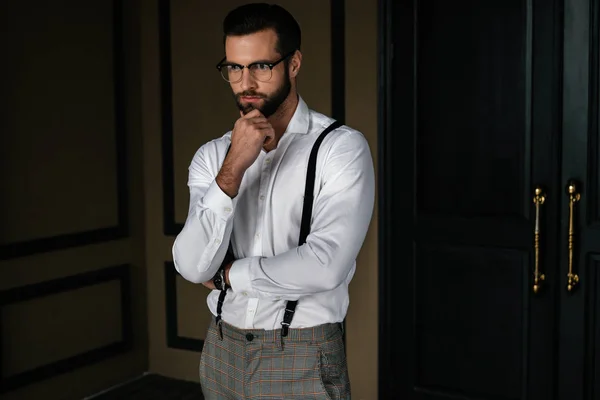 Bonito barbudo pensivo homem em branco camisa e suspensórios — Fotografia de Stock