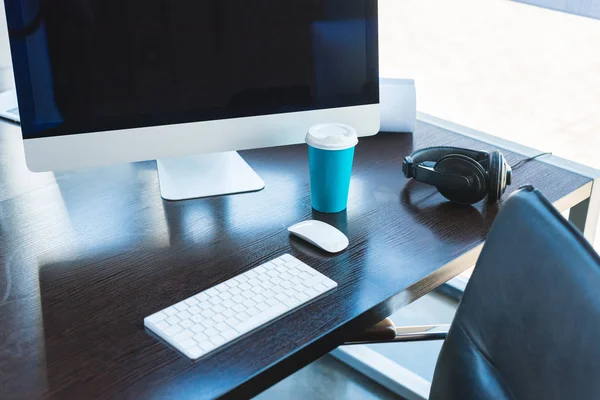Tavolo con computer, tastiera e tazza di caffè in ufficio — Foto stock