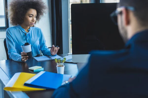 Mujer de negocios afroamericana sosteniendo taza de café en la oficina - foto de stock