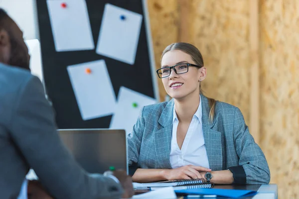 Smiling multicultural businesswoman and businessman talking in office — Stock Photo